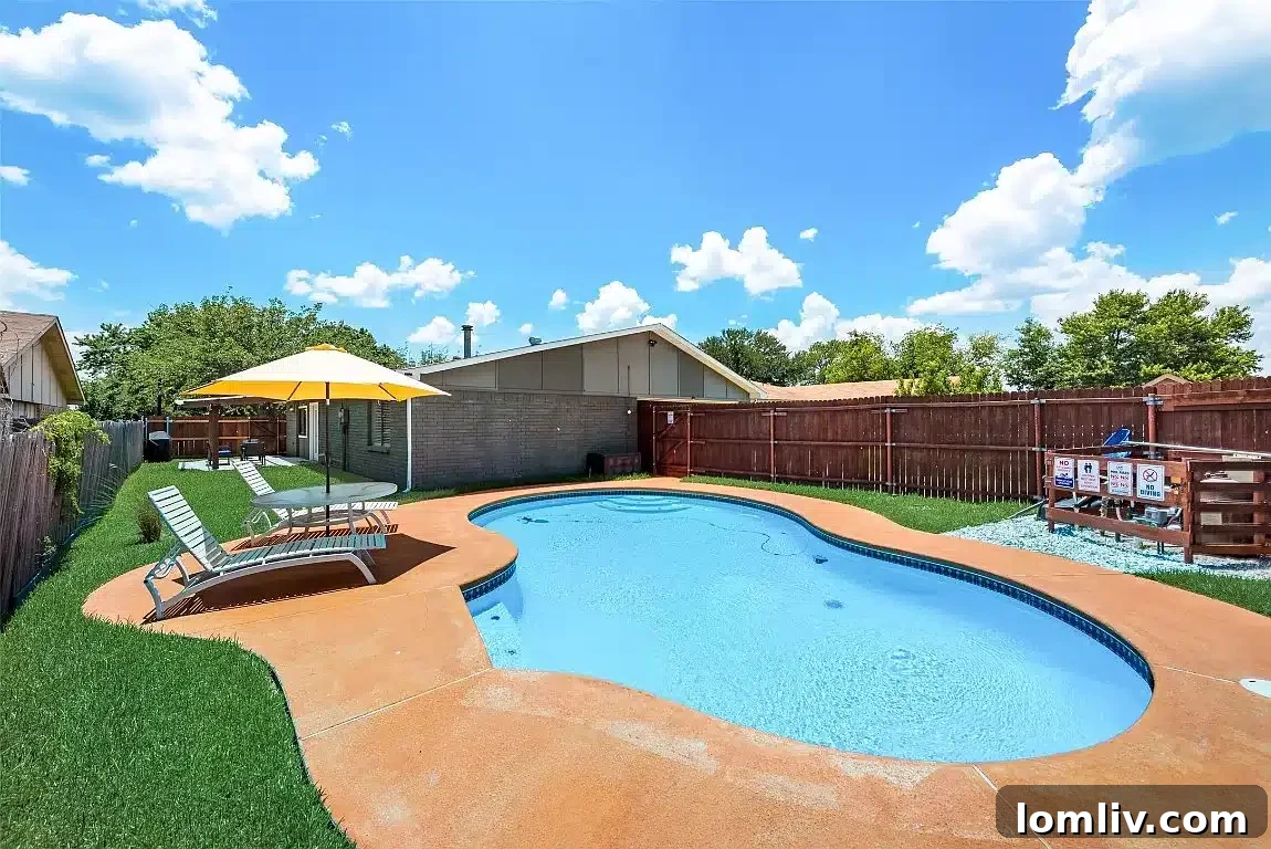 A pristine blue swimming pool in the backyard, inviting residents to relax and enjoy.