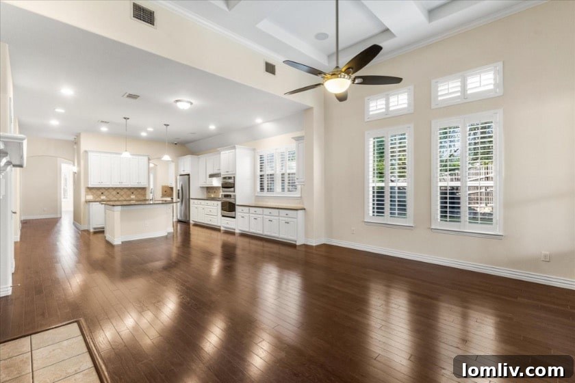 Inviting covered flagstone patio providing an ideal outdoor living space, overlooking a meticulously landscaped backyard