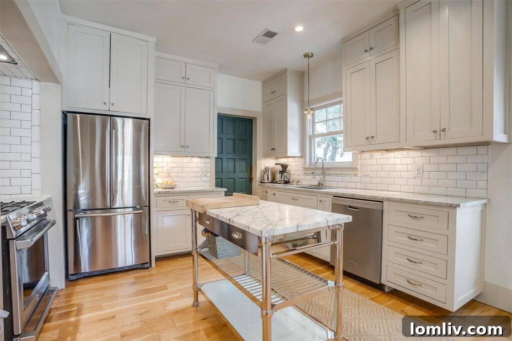 Modern kitchen with floor-to-ceiling white cabinets, marble countertops, and a commercial-grade range.