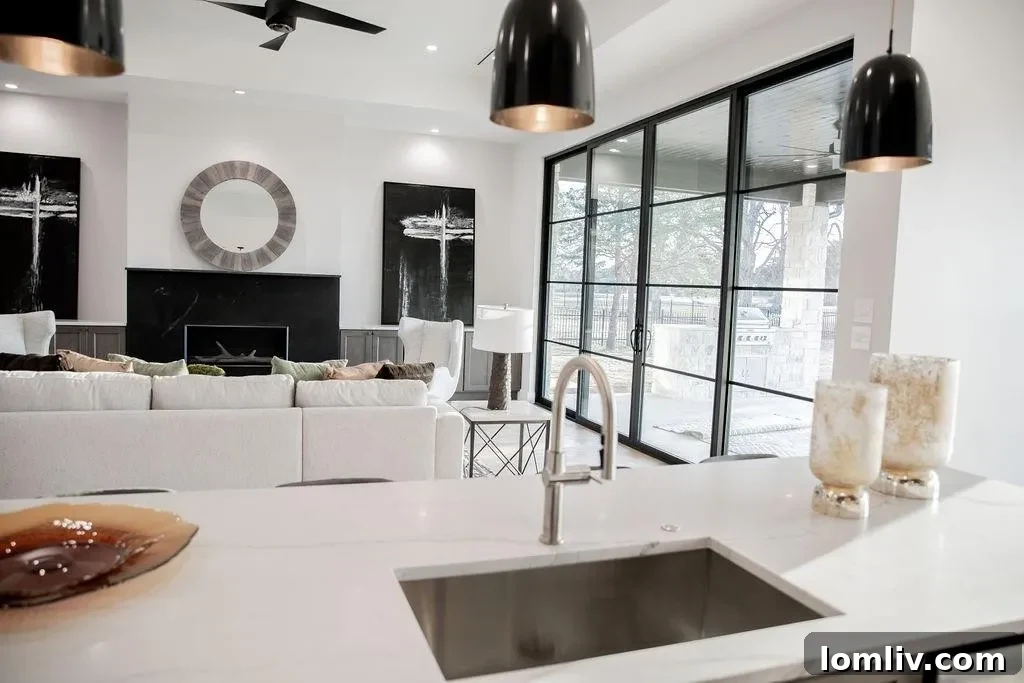 Modern gourmet kitchen featuring an oversized Mont Lucia quartzite island with Arteriors pendants and Jennair professional appliances