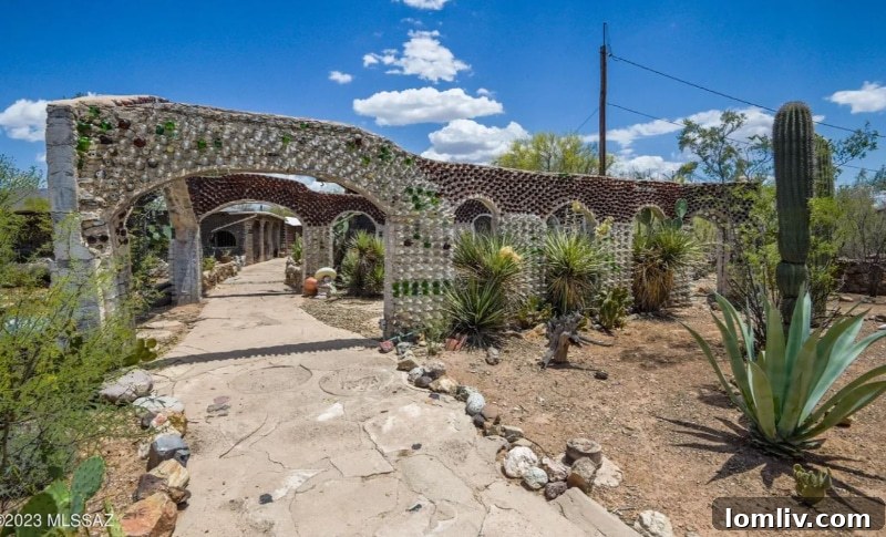 Arizona Bottle House exterior, featuring walls made from thousands of colorful recycled glass bottles and natural stone elements, set against a desert landscape.