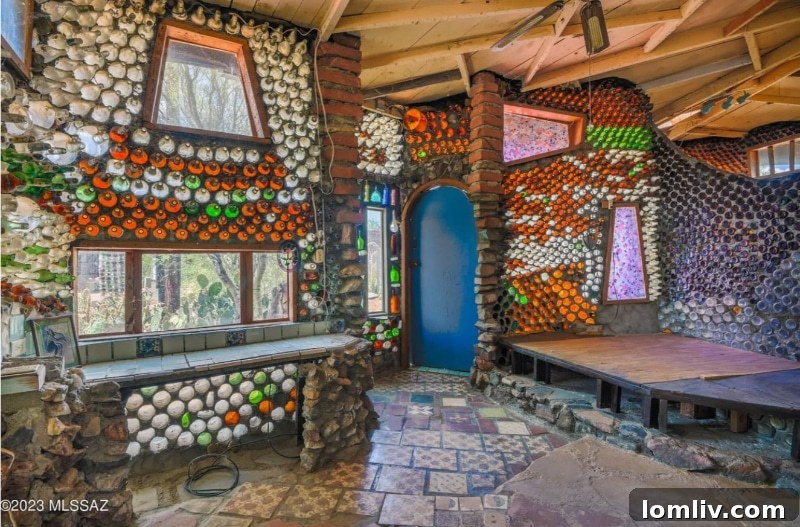 A unique interior corner of the bottle house, showcasing the intricate bottle masonry work and how light permeates through the glass, creating a colorful glow.