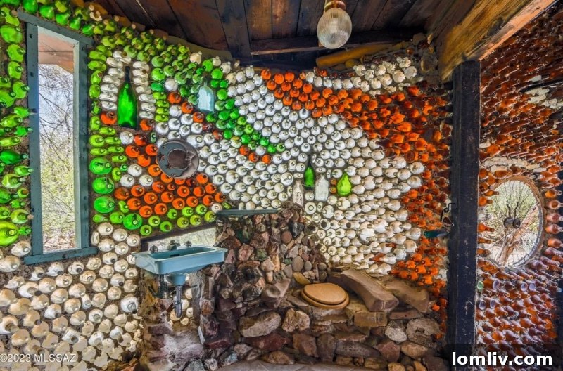 The unique bottle house bathroom, featuring walls intricately built with recycled glass bottles, creating a colorful and artistic washroom environment.