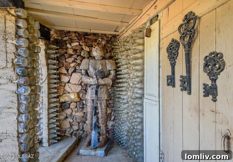 Another perspective of the bottle house interior, showcasing a wider view of the living space with its distinctive bottle walls and rustic charm.