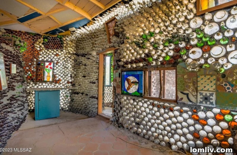 An artistic detail within the bottle house, featuring a unique decorative element, possibly a suit of armor, complementing the unconventional bottle and rock walls.
