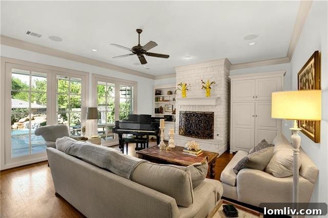 Spacious family room with a second fireplace, built-in shelving, and views of the backyard oasis