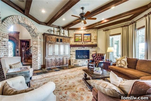 Gourmet kitchen featuring a large island, copper sink, and brick-accented archways