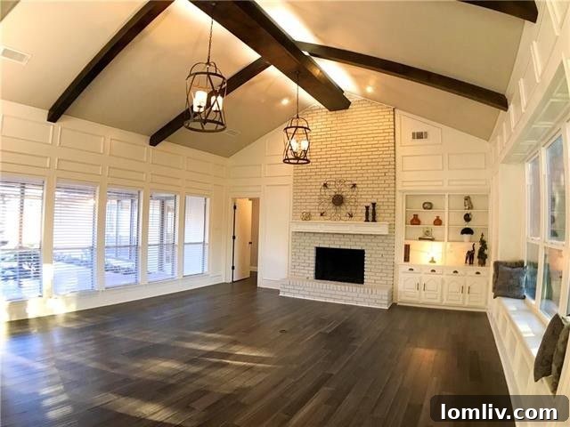 Spacious living area with vaulted ceilings, a cozy fireplace, and modern bamboo flooring at 16114 Fallkirk Drive