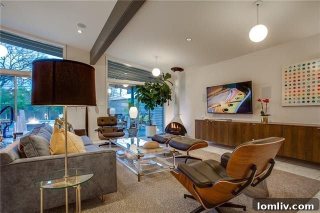 The great room, featuring a freestanding Malm fireplace, beamed and vaulted ceilings, and a wall of windows leading to the pool