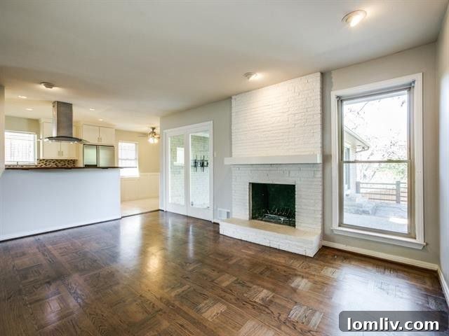 Merriman Park Masterpiece: Complete Living, Unmatched Price 5 Spacious living area with modern white brick fireplace and large windows overlooking the yard