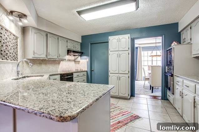 Modern kitchen with granite countertops, stainless steel appliances, and mosaic backsplash.