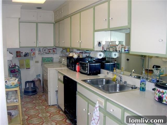 The original, dated kitchen in Unit 1313 at The Athena, showing its compact, pocketed layout.