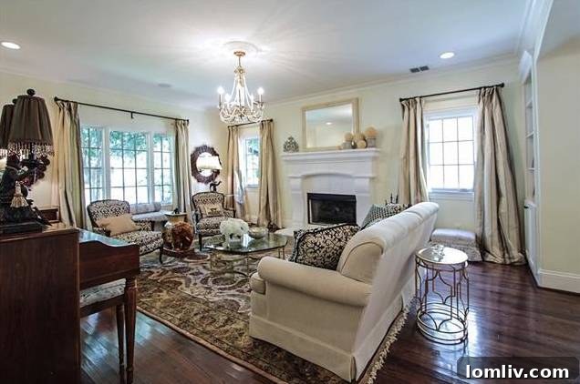 Spacious living room with natural light and elegant hardwood floors in Tudor home