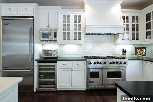 Modern kitchen with white cabinetry, Carrara marble countertops, and commercial-grade appliances