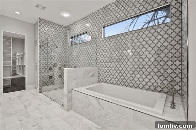 Custom tile, frameless glass shower, and jetted tub in a luxurious master bath.