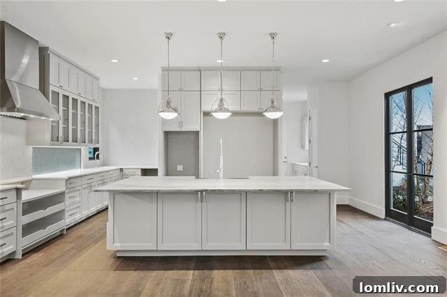 Gourmet kitchen with double-height cabinets and a large two-sided island for abundant storage in a custom Dallas home.