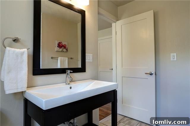 Wide view of the renovated kitchen, highlighting the large-format tile floor and the abundance of natural light.