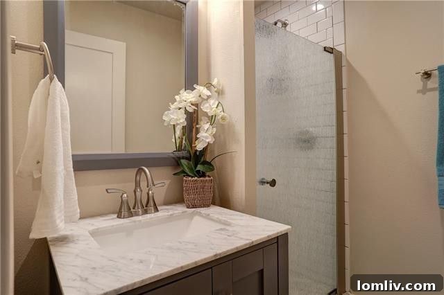 A closer look at the kitchen's granite countertops and elegant white subway tile backsplash, complementing the modern appliances.