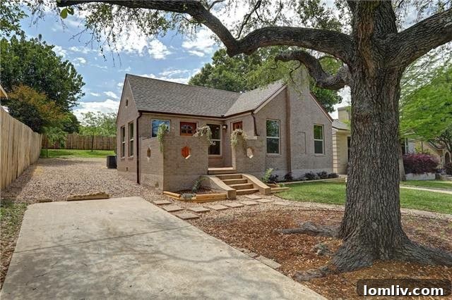 Elegant living room featuring original hardwood floors and a classic decorative fireplace, perfect for cozy gatherings.