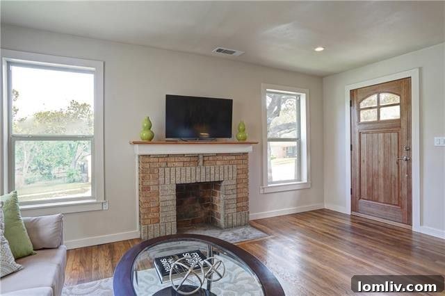 Bright and spacious primary bedroom with original hardwood floors and ample natural light from updated windows.