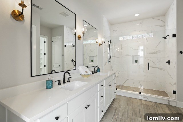 Master ensuite bath with dual sinks, custom lighting, quartz counters, frameless glass shower