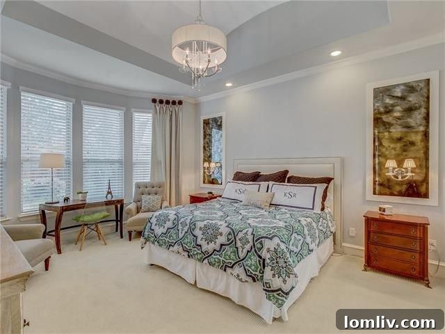 Modern kitchen with white cabinetry, stainless steel appliances, and a large island, illuminated by natural light.
