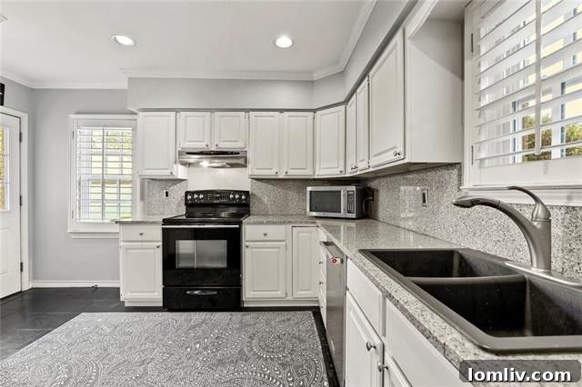 Bright Renovated Kitchen with White Cabinets and Stainless Steel Appliances