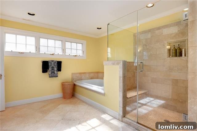 Spacious master bedroom featuring a comfortable sitting area and abundant natural light