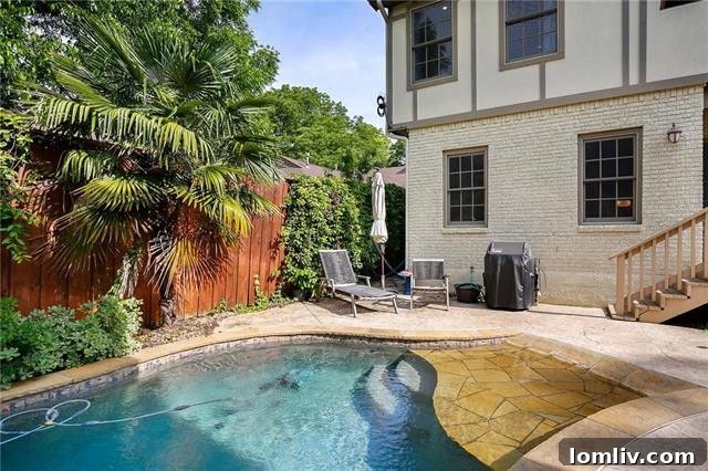 Inviting backyard oasis with a sparkling swimming pool, spacious deck, and mature trees