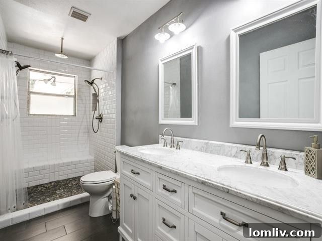 Beautifully updated master bathroom featuring elegant marble countertops and crisp white subway tile