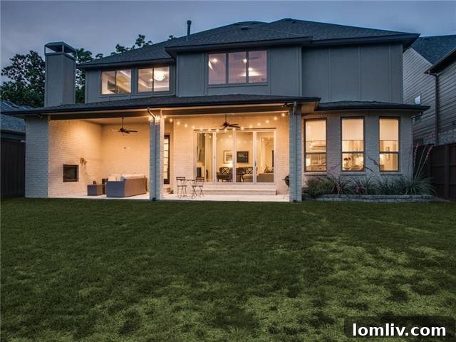 Inviting covered patio with an outdoor fireplace overlooking a sprawling green backyard