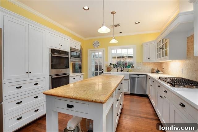 Modern kitchen with stylish white glass-front cabinets, quartz and granite countertops, and stainless steel appliances
