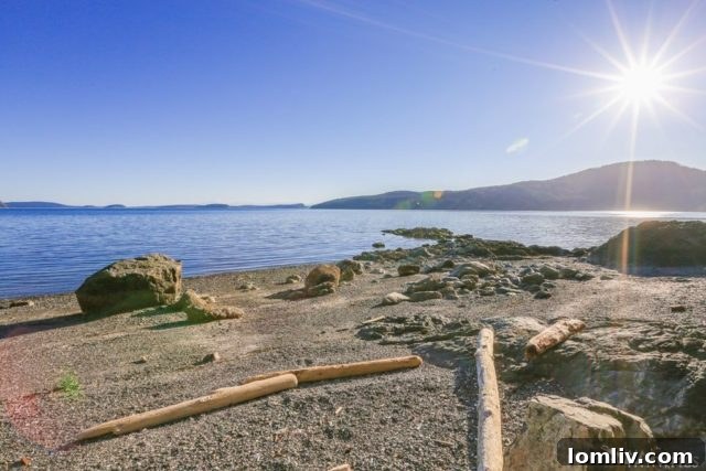 A picturesque, rugged pebble-stone beach leading to calm waters under a soft sky, showcasing the natural beauty of Orcas Island.