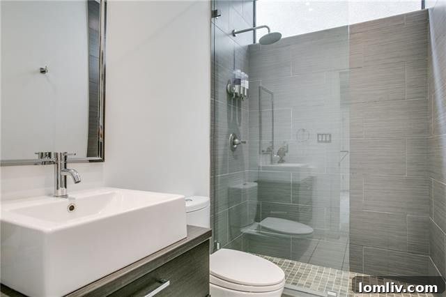 Modern renovated bathroom with glass shower and floating shelves at 9119 Chapel Valley Road