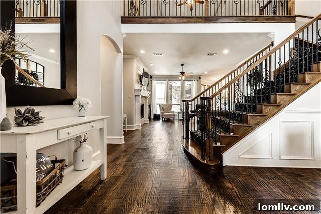 Grand entry with a sweeping scrolled-iron staircase and soaring ceilings inside 4518 Siena Drive Frisco