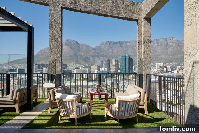 A rooftop view from The Silo Hotel, showing the infinity pool and lounge area overlooking Cape Town and Table Mountain.