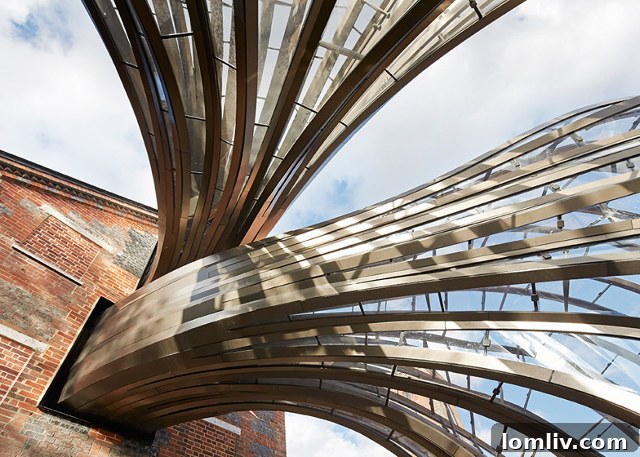 The glass and steel 'umbilical cords' connecting the historic mill building to the modern greenhouses at Bombay Sapphire Distillery, resembling Doctor Who architecture.
