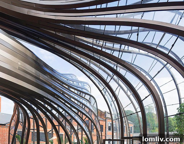 The curving glass and steel structures of the Bombay Sapphire Distillery greenhouses, resembling alien hands extending towards the ground.