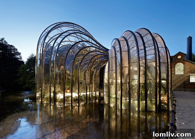 The two dramatic greenhouses of the Bombay Sapphire Distillery, one tropical and one Mediterranean, reflected in the adjacent pond.