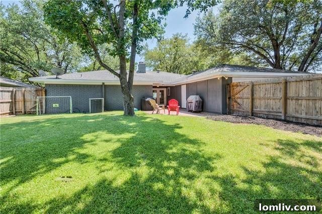 Private backyard with mature trees, open patio, and lush green space