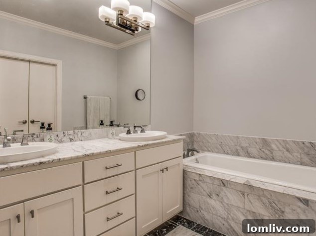 Arch Adams Townhouse: Modern Elegance, Prime Address 12 Master bathroom with luxurious dual sinks and black and Carrara marble finishes