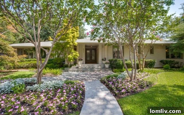The elegant facade of 6815 Prestonshire Lane, nestled under a canopy of mature trees in Preston Hollow.