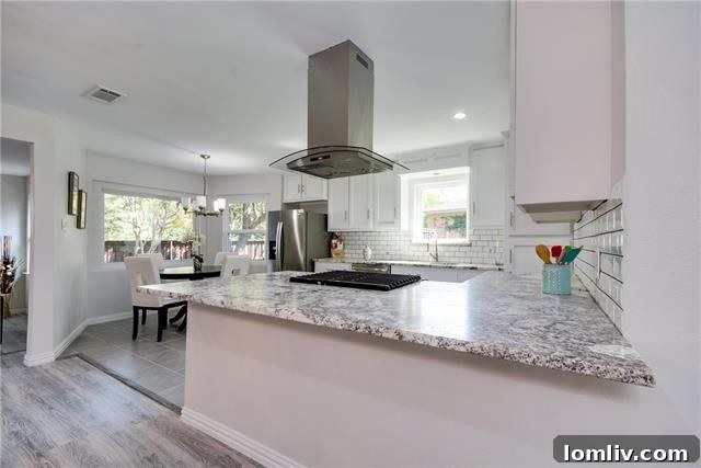 Kitchen view showing the spacious layout and ample white cabinetry for storage.