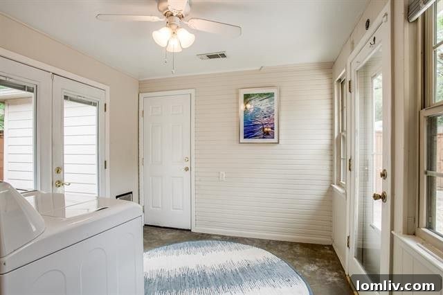 Side view of the Elmwood cottage with mature tree at 1918 Newport Ave
