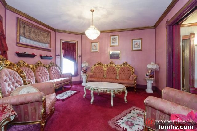Another view of a densely furnished pink room with decorative elements and intricate lighting