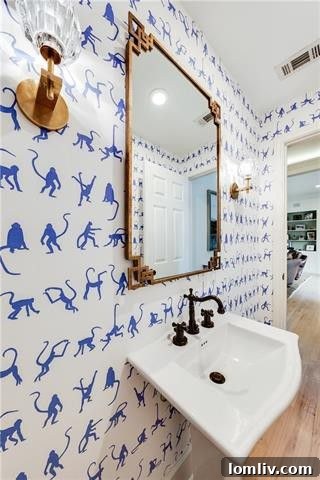 Charming powder bath with blue monkey wallpaper and elegant fixtures