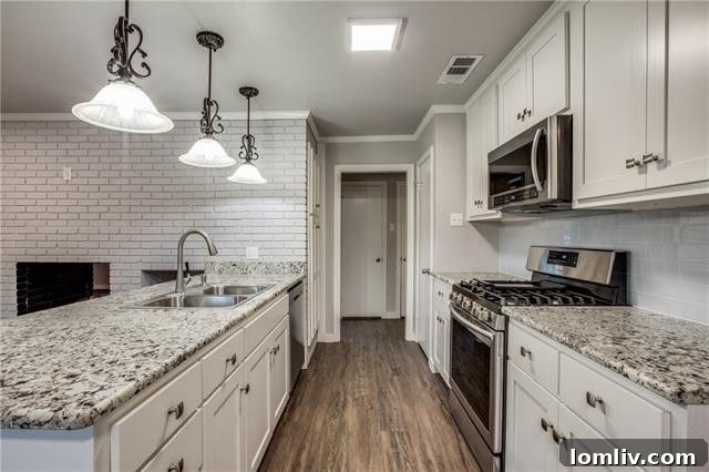 View of the dining area adjacent to the kitchen, showcasing modern lighting and updated finishes.