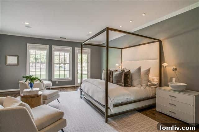 Expansive master bedroom with elegant decor and natural light