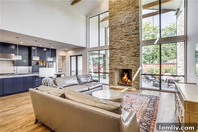 Stunning living room with a 23-foot fireplace, flanked by two-story windows, showcasing exceptional natural light and design.
