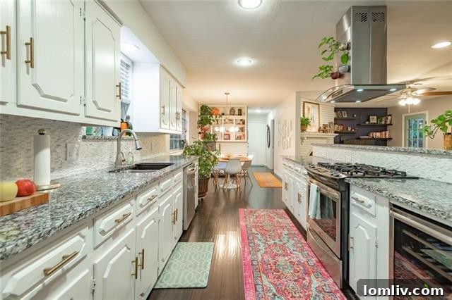 Modern kitchen with large island, cooktop, wine cooler, and stainless steel appliances.